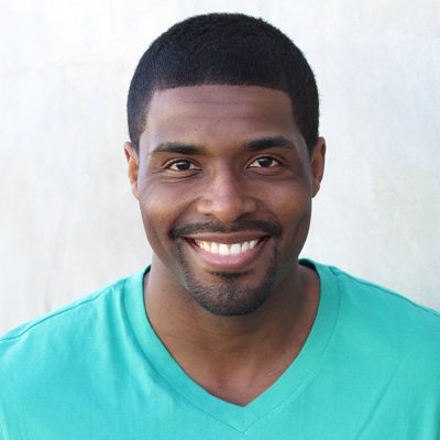 The image shows two elderly individuals, a man and a woman, posing for a photograph with smiles on their faces, embracing each other, against a backdrop of a natural landscape with clear skies.