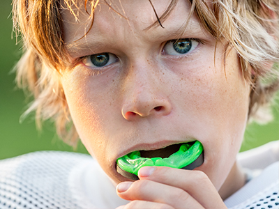 The image shows two photos of a young boy with blonde hair, holding a green object that resembles an apple, possibly a toy or a piece of plastic.