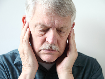 The image shows a man with his hand on his ear, possibly in discomfort or surprise, with an  alt  tag that could read   A middle-aged man with his hand on his ear, likely in pain or confusion.